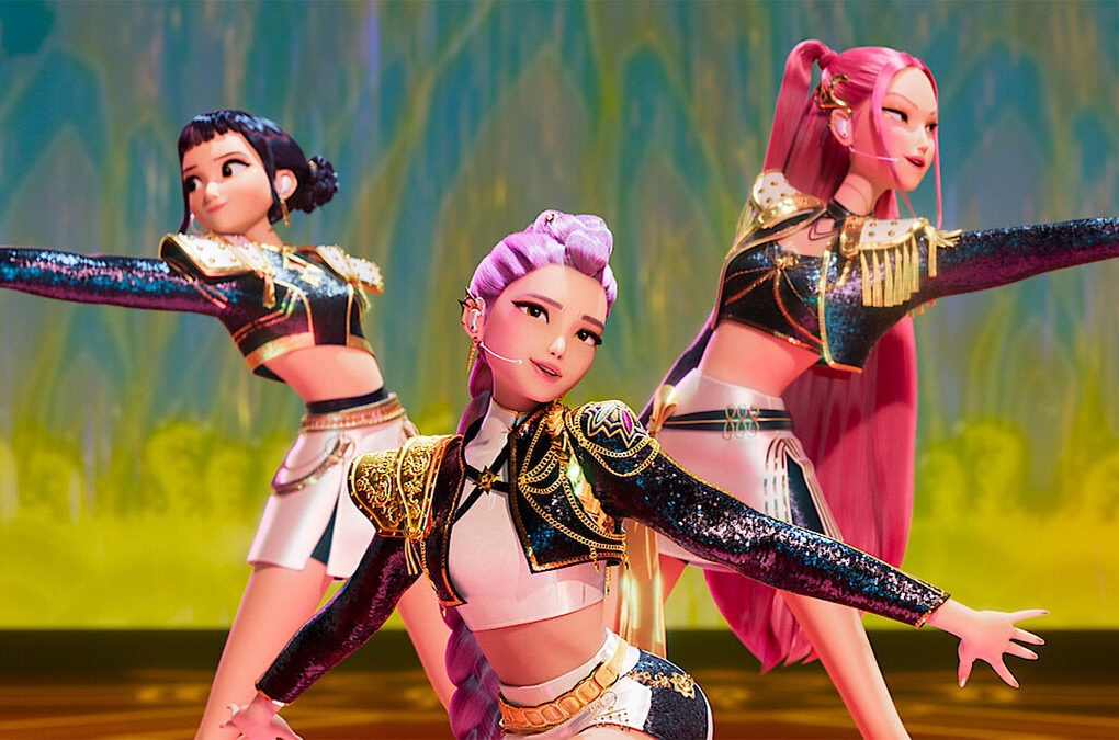 Three animated K-pop idols performing a synchronized dance on stage, wearing glittery futuristic outfits with gold details, from the movie K-Pop Demon Hunters